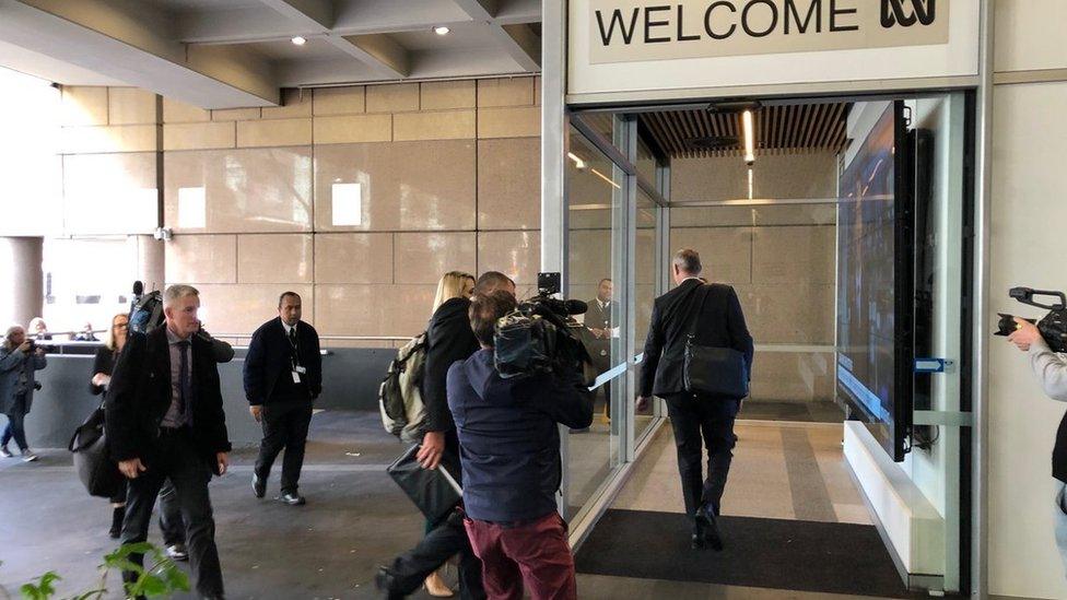 Police officers walking into ABC building