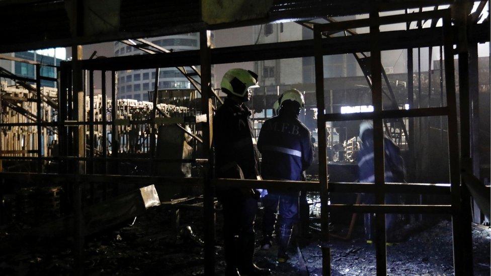 Firemen inspect the debris after the fire