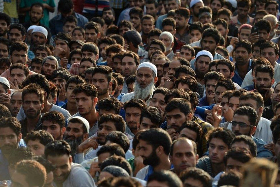 Kashmiri mourners look on near the body of Burhan Muzaffar Wani, the new-age poster boy for the rebel movement in the restive Himalayan state of Jammu and Kashmir, during his funeral in Tral, his native town, 42kms south of Srinagar on July 9, 2016.