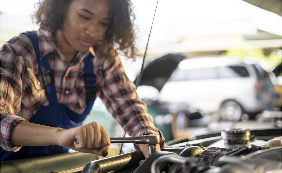 Young mechanic fixing car (stock photo)