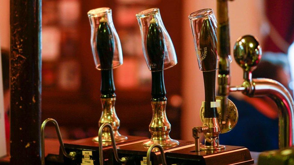 Empty pint glasses sit on the top of beer pumps