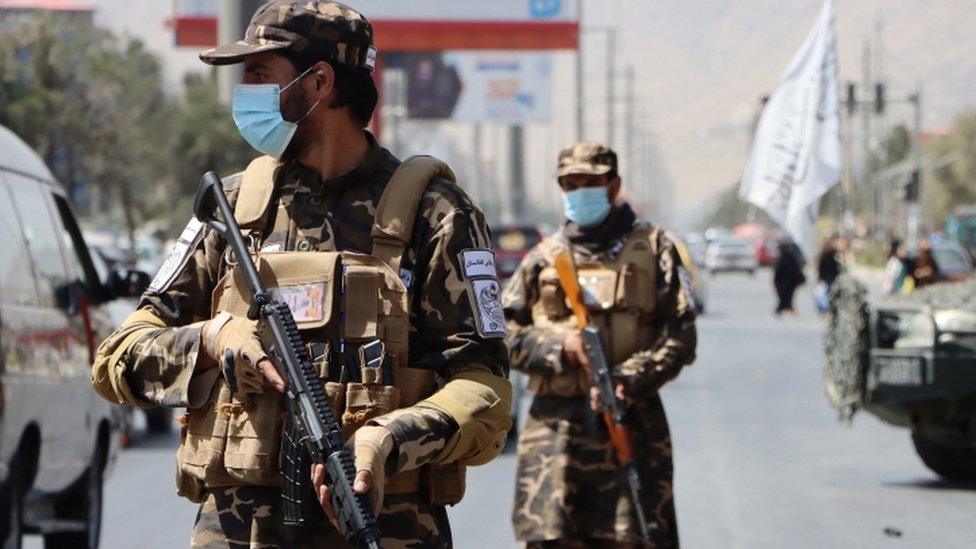 Taliban forces stand guard at a roadside checkpoint in Kabul, Afghanistan