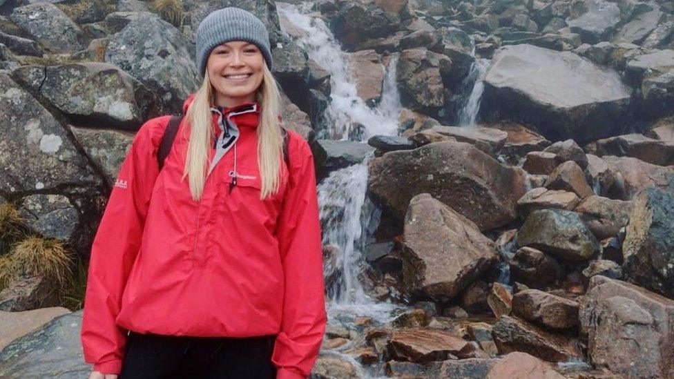 Phoebe smiling in front of a waterfall