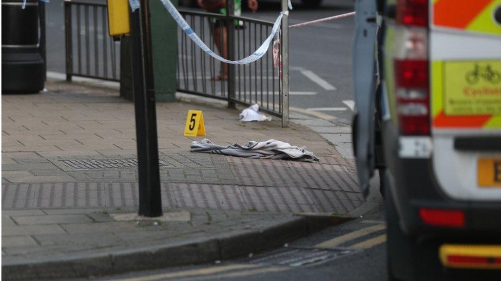 An item of clothing lies on the pavement at the junction of Palmerston Road and Wealdstone High Street