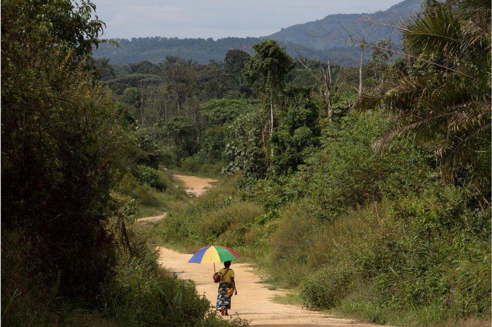 Tantine Katangalo carries her daughter down a country road