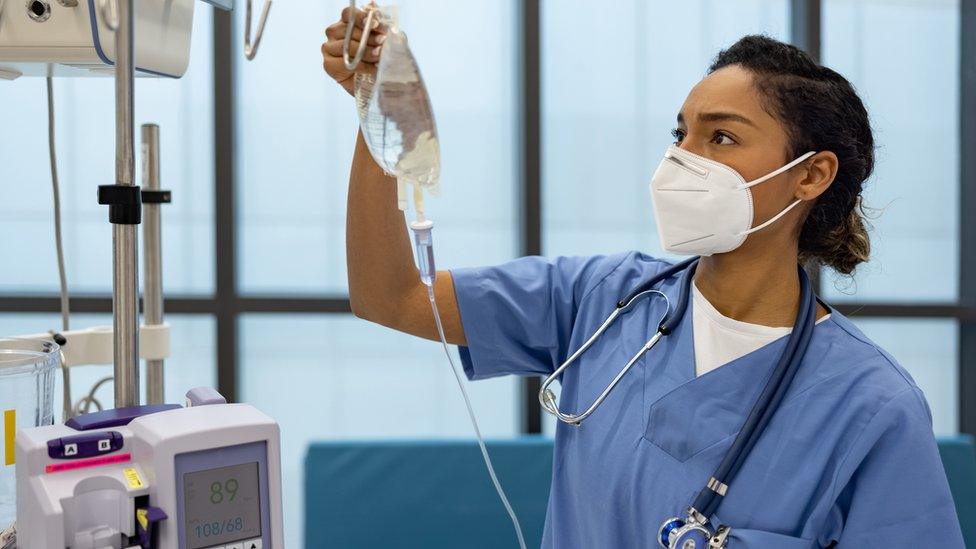 Nurse at the hospital putting an IV Drip on a patient