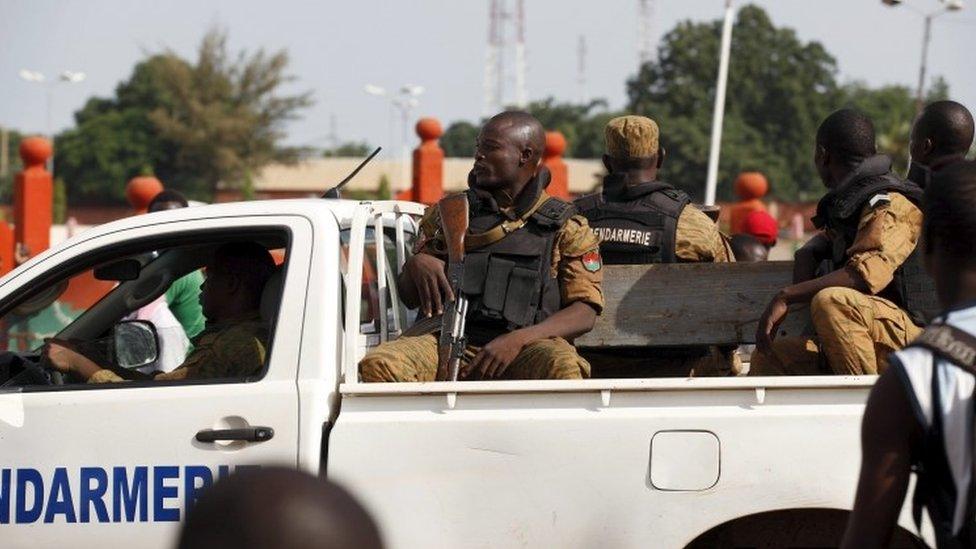 Gendarmes drive by anti-coup protesters in Ouagadougou, Burkina Faso, September 22, 2015.