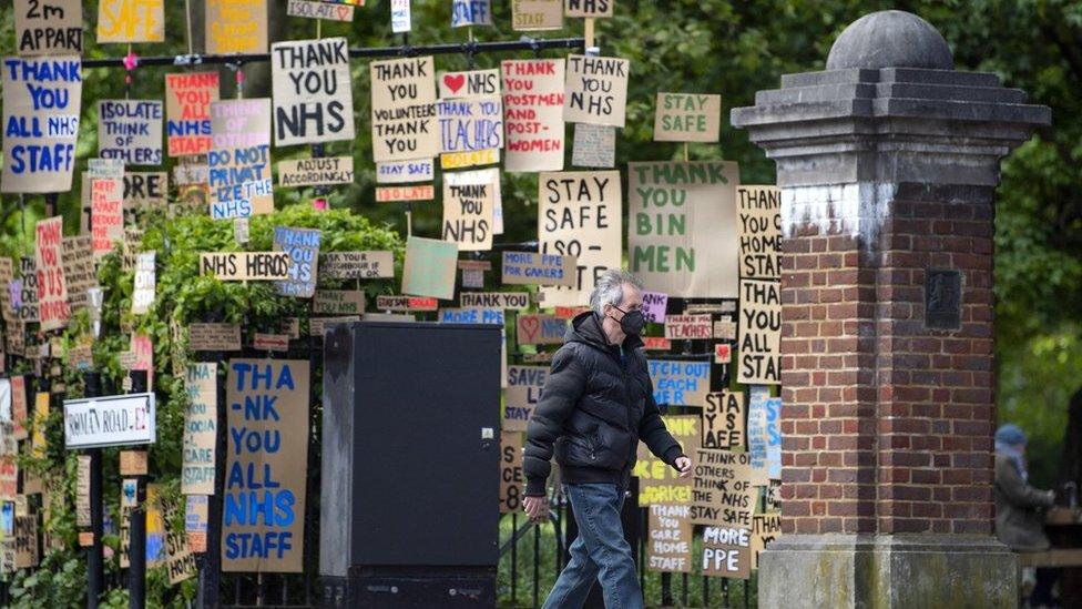 man-facemask-walks-signs-thank-you-nhs.