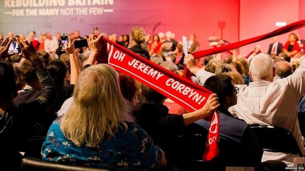 Woman holding up Jeremy Corbyn scarf at 2018 conference