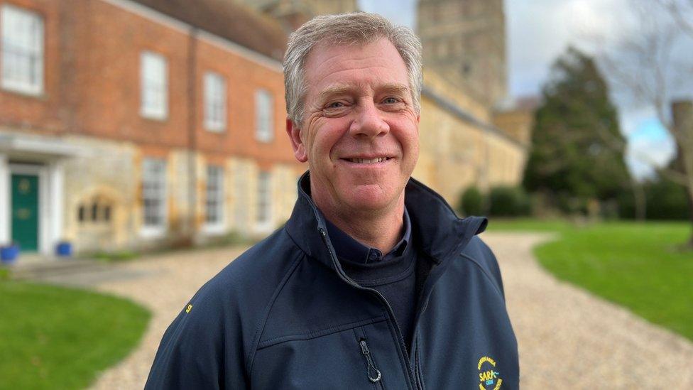 David Hill outside a big house smiling