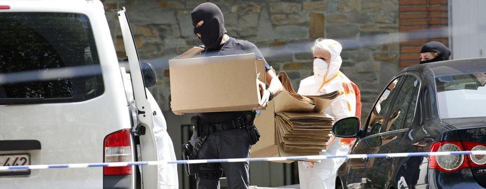 Forensic police leave the suspect's home in Molenbeek with several boxes (21 June)