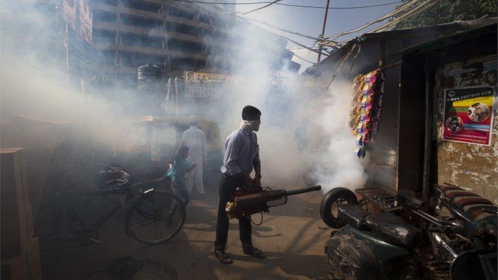 A municipal worker Sunil Chauhan fumigates an impoverished colony to check the spread of mosquito-borne diseases in New Delhi, India, Friday, Sept. 2, 2016.