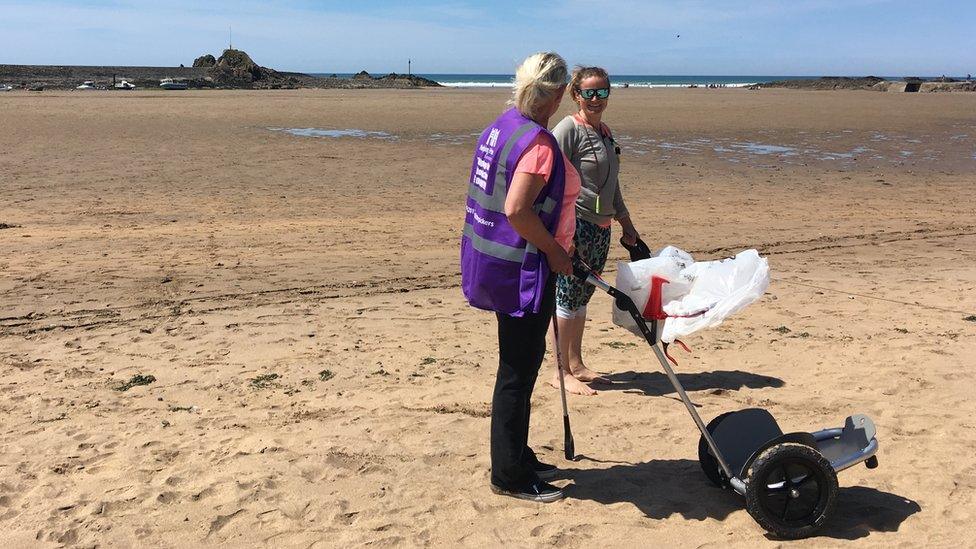 Two women litter picking on a beach