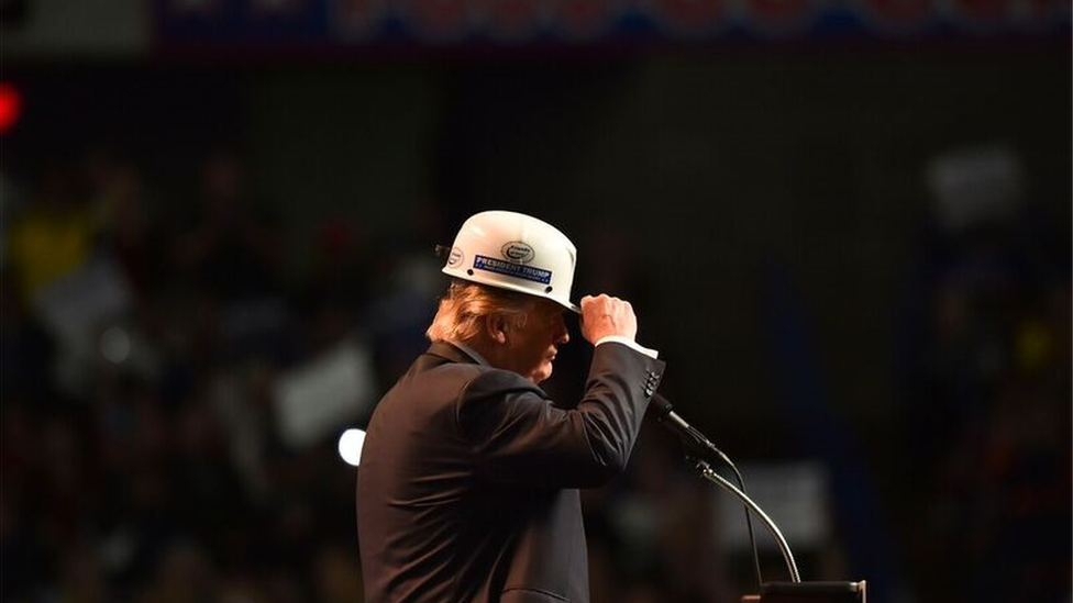 Trump speaks with a coal miner's helmet on