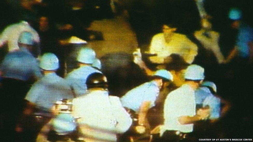 A group of policemen in riot gear confronting a crowd at the convention