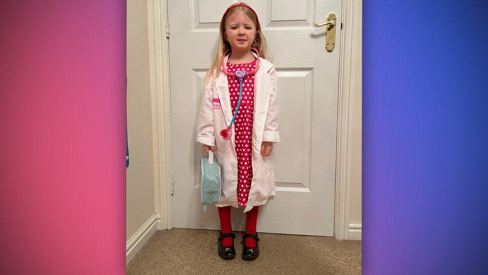a girl wearing a doctor's white coat and a stethoscope
