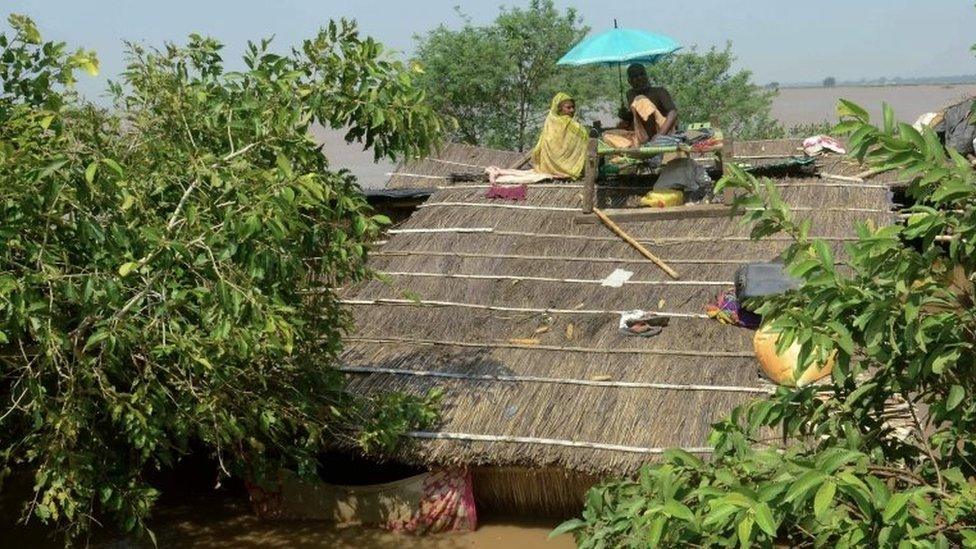 Flood affected people sit on the roof of their submerged house at Kasimpurchak, near Danapur Diara in Patna in eastern Bihar state.