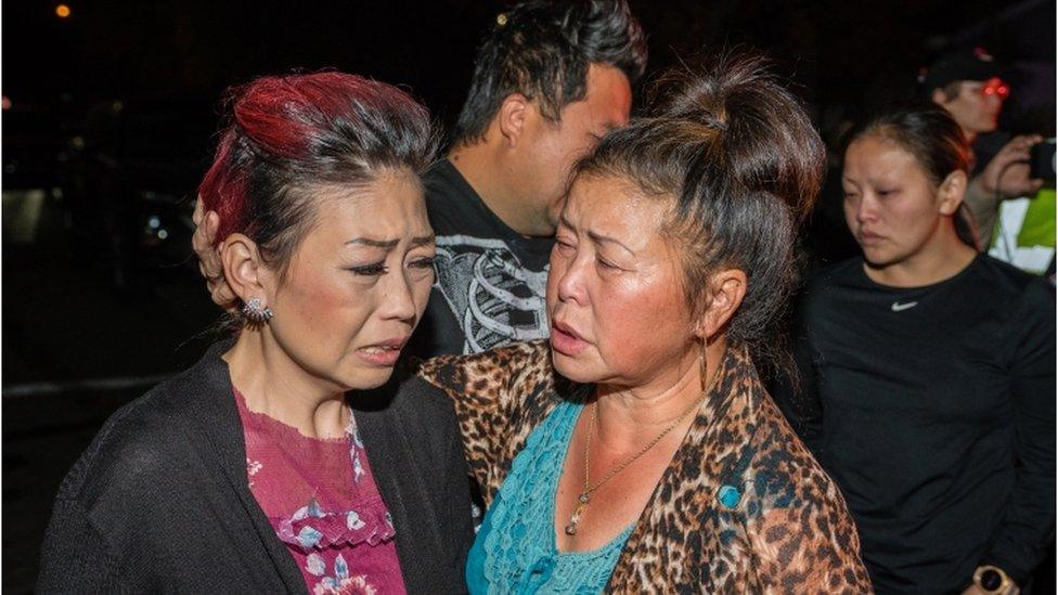 People react near the scene of a shooting in Fresno