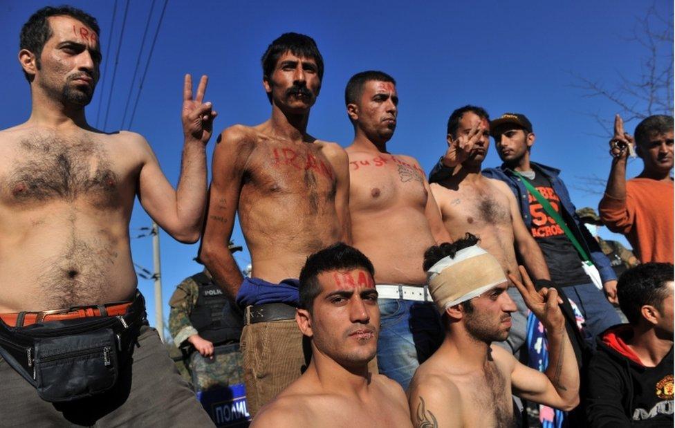 Migrants and refugees from Iran with their mouths sewn shut sit on railway tracks as they wait to cross the border of Greece and Macedonia 23 November 2015.