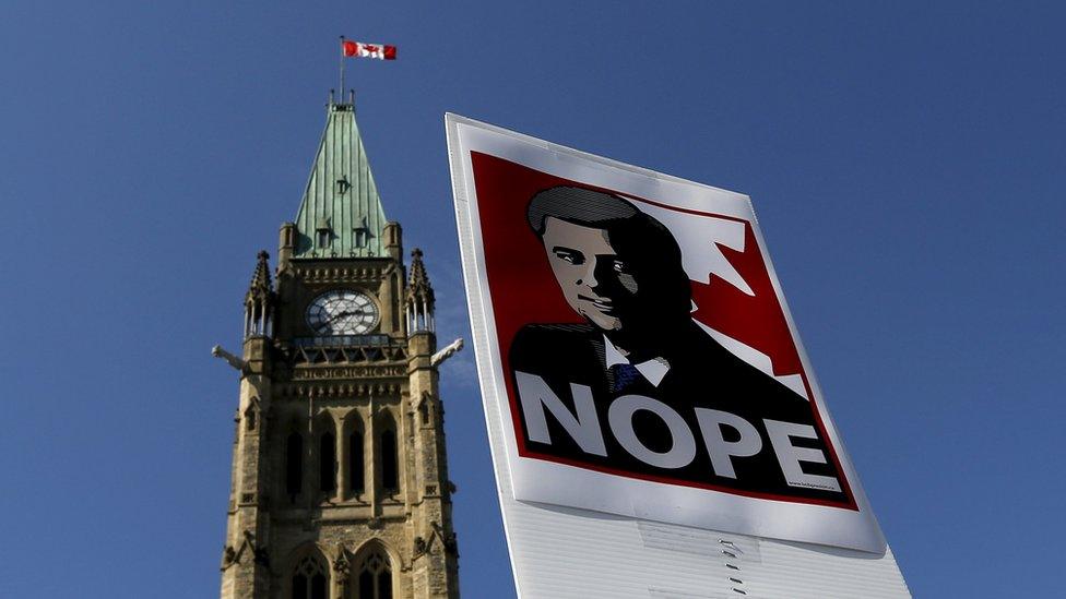 A sign featuring an illustration of Conservative leader and Canada"s Prime Minister Stephen Harper is pictured during a singalong performance of "Harperman," a protest song against Harper, on Parliament Hill in Ottawa, Ontario September 17, 2015.