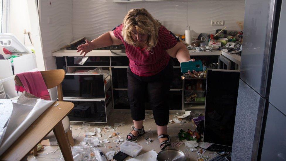 Victoria Tapalashvili checks the damage after a rocket fired from the Gaza Strip hit near her house on May 17