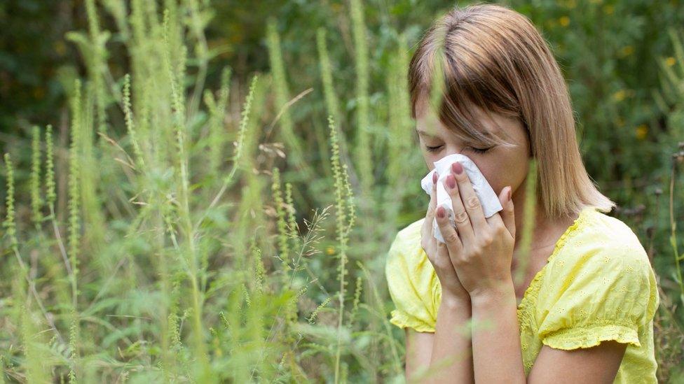 A woman blowing her nose