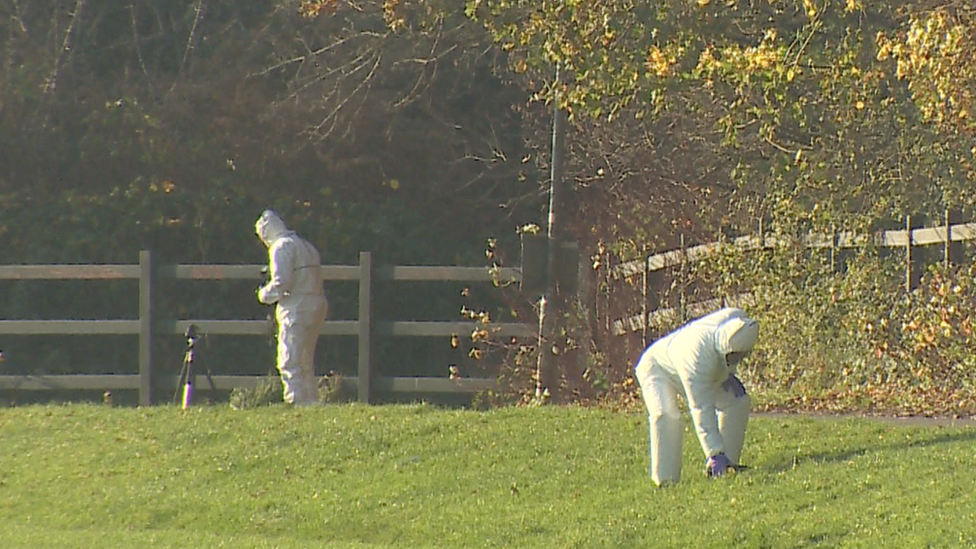 Forensics officers scour the scene