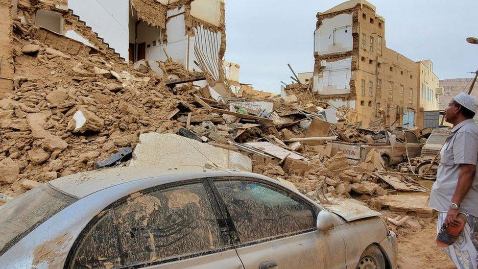 A man looks at a collapsed building in Tarim, Yemen, following flooding (3 May 2021)