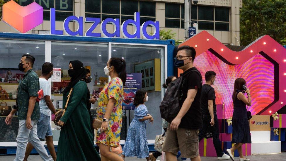 People walk past a pop-up store by Asian e-commerce giant Lazada along Singapore's Orchard Road shopping district.