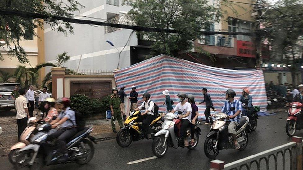 Motorcyclists drive past a police station in Ho Chin Minh city in June 2018