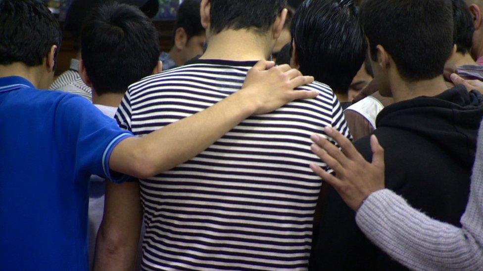 A group of Iranian converts pray with each other