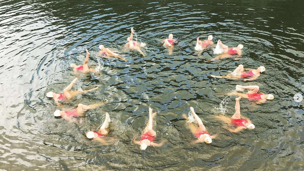 Synchronised swimmers performing in open water