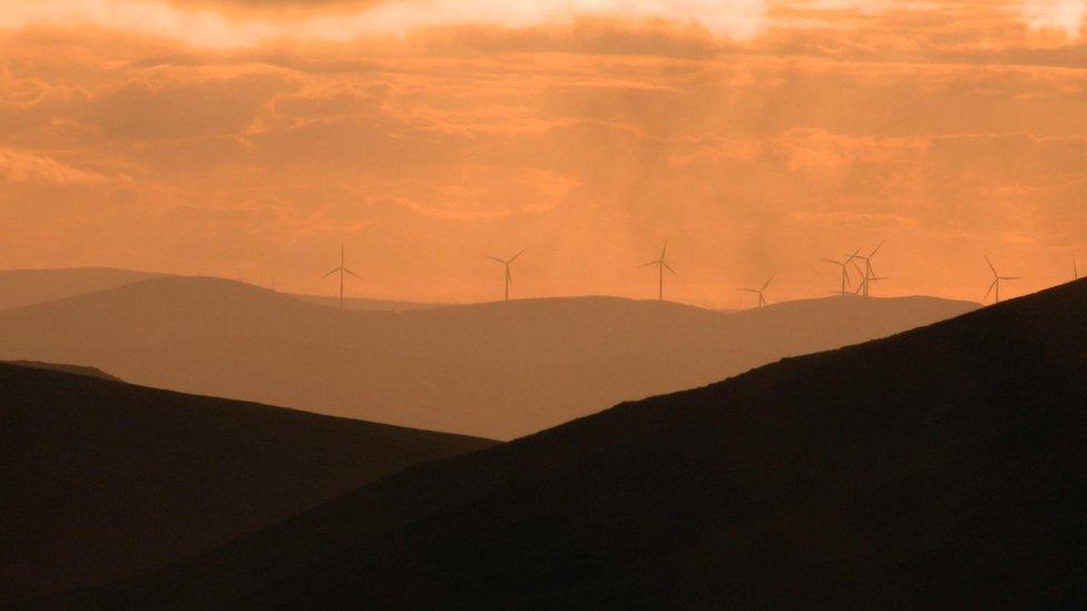 Wind turbines at the summit of Clyde Law, from where water trickles to