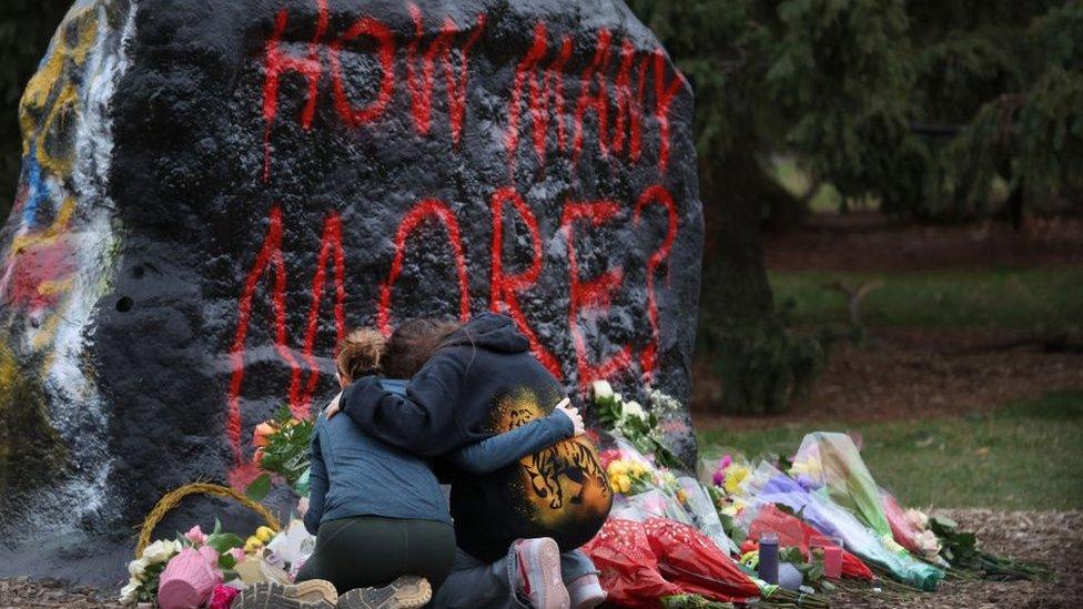 People leave flowers at a makeshift memorial at Michigan State University