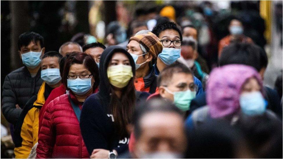 People line up in Hong Kong to to purchase face masks from a makeshift stall