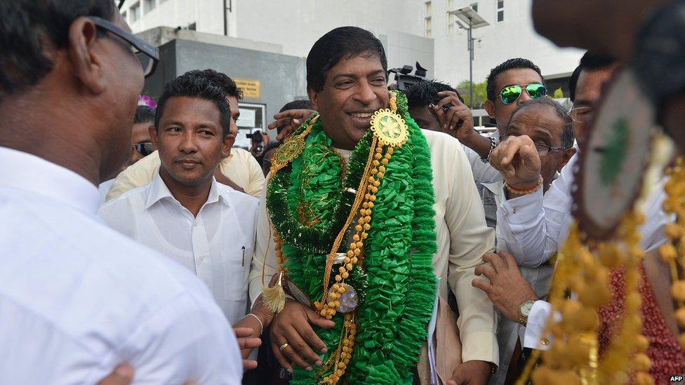 Ravi Karunanayake (centre) is garlanded soon after submitting nominations to stand in August's elections (file picture)