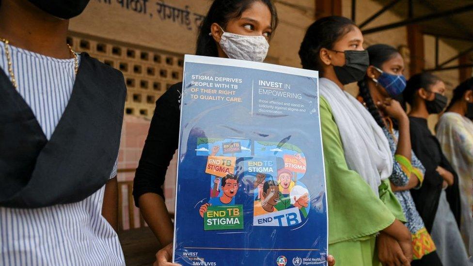 A school girl holds a placard raising awareness on the tuberculosis