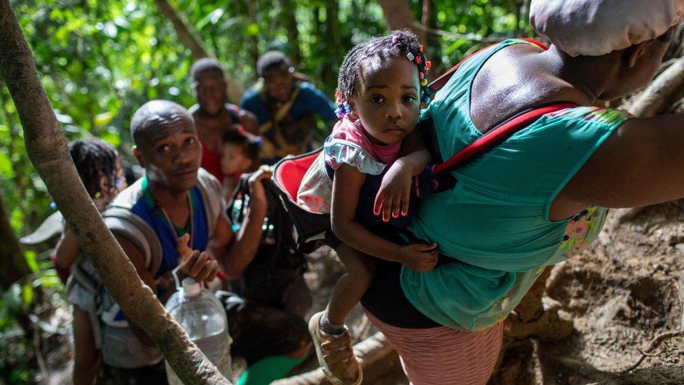 Immigrant families from Haiti climb a steep mountain trail near the border with Panama on the second day of their trek October 19, 2021 through the Darien Gap, Colombia.