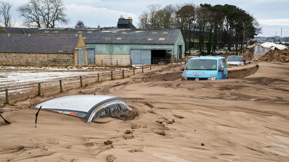 Cars buried in muddy snow