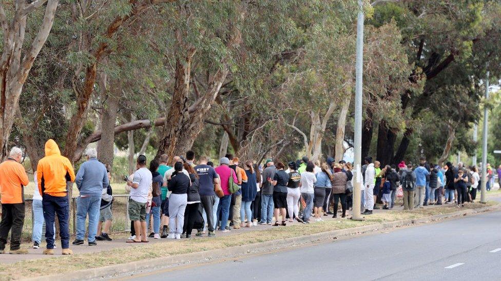 A long queue of people waits to be tested in Adelaide on Monday