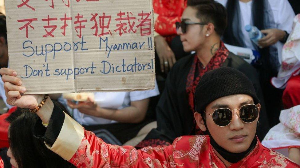 Paing Takhon holding up a sign