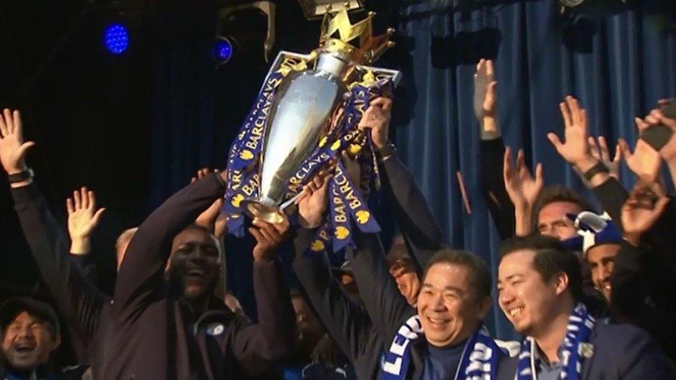 The Thai owners and captain Wes Morgan raise the trophy