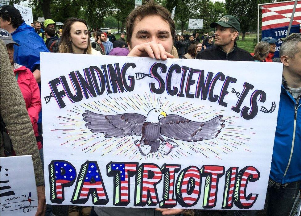 Man with Funding Science is Patriotic placard