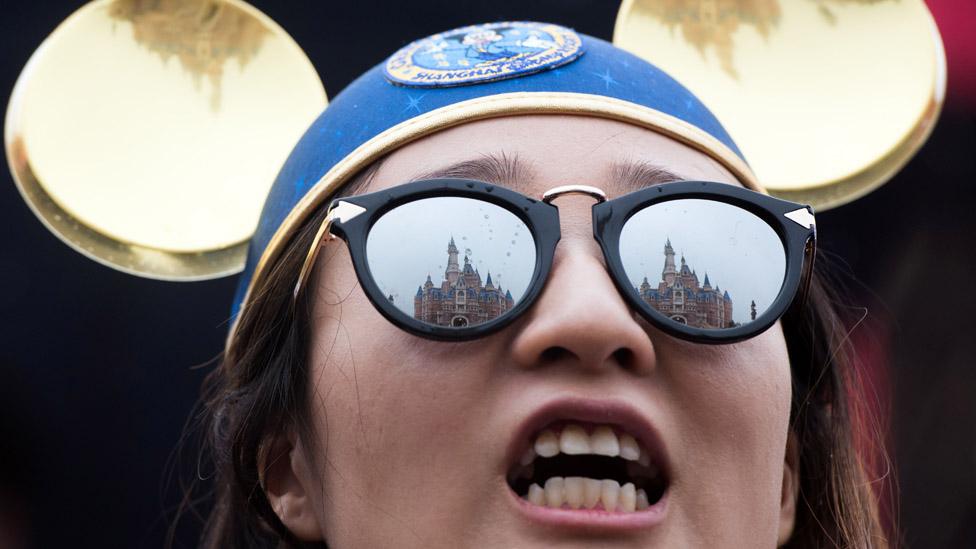 The Enchanted Storybook Castle is reflected in the sunglasses of a girl during the opening ceremony of the Shanghai Disney Resort in Shanghai on June 16, 2016.