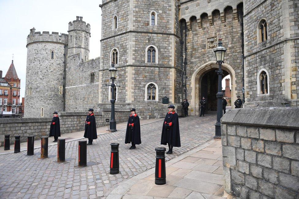 Windsor Castle staff stand outside Windsor Castle, a day after the passing of Britain's Prince Philip, in Windsor, Britain, 10 April 2021.