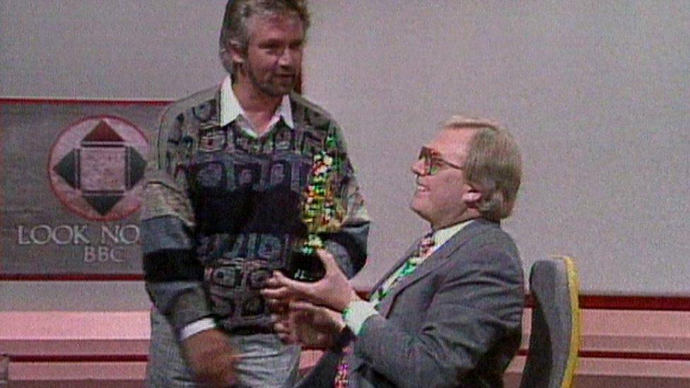 Noel Edmonds presenting Mike Neville with a "Gotcha"