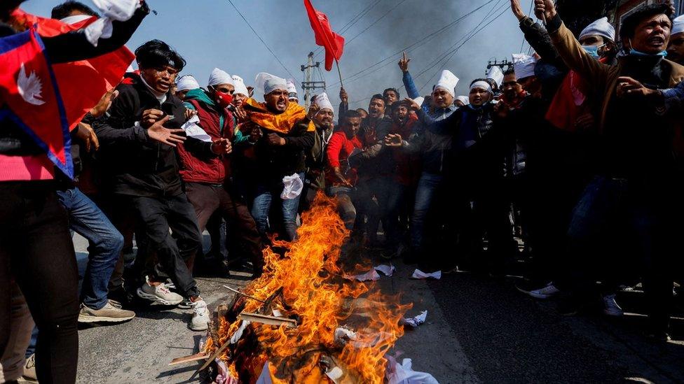 Protesters cremate a dummy corpse representing the US grant they oppose