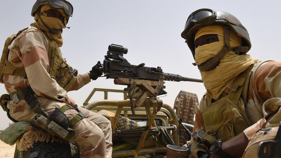 Nigerian soldiers sitting on the back of an army truck