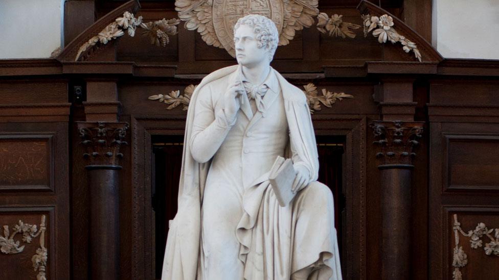 A statue of Lord Byron, holding a pencil to his chin, Wren Library, Trinity College