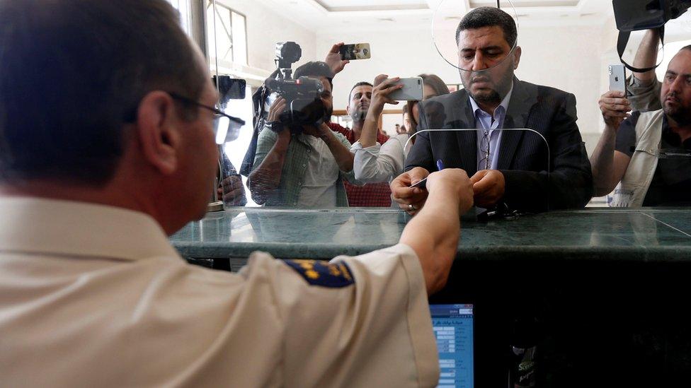 A Syrian man gets his passport stamped at Jordan's Jaber border point, near the Nassib crossing (15 October 2018)